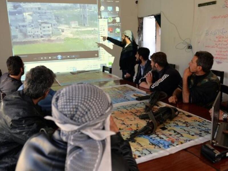 Fighters from the rebel al-Ezz bin Abdul Salam Brigade take part in a briefing at the brigade's base at an undisclosed location near the al-Turkman mountains, in Syria's northern Latakia province earlier this week. AFP Photo