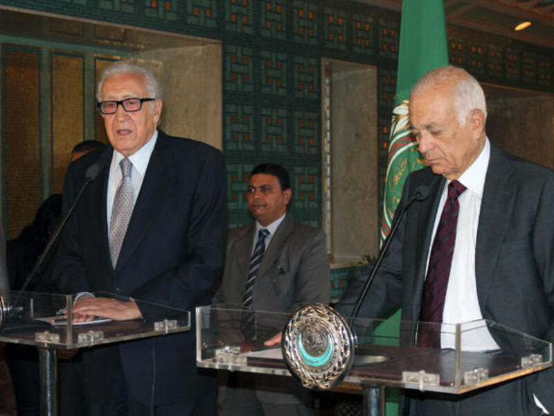 Arab League general secretary Nabil al-Arabi (R) listens to UN-Arab League envoy to Syria Lakhdar Brahimi speaking during a press conference following their meeting on October 20, 2013. (Image credit: AFP)