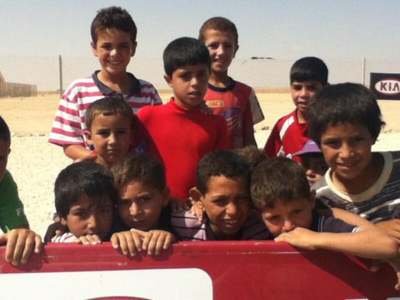 Syran refugee children at Zaatari camp awaiting their turn to play football at a workshop organized by Brazilian  coaches (Al Bawaba) 