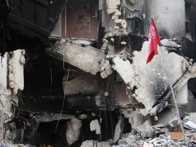 Rebel fighters walk in the rubble of destroyed building in Syria. (Image credit: AFP)
