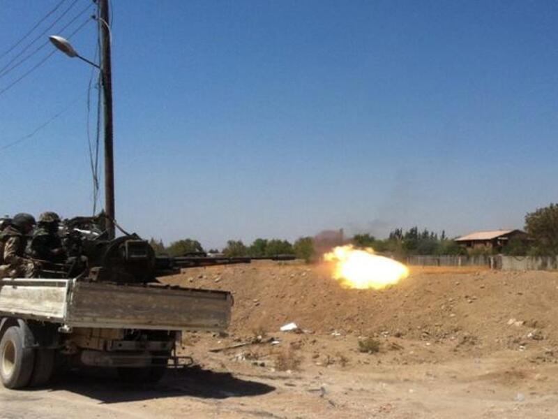 Syrian troops fire a heavy machine gun mounted on a pick-up truck in the Eastern Ghouta area on the northeastern outskirts of Damascus on August 30, 2013. TOPSHOTS/AFP PHOTO/SAM SKAINE