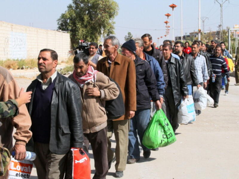 Syrian civilians evacuate the war-battered suburb of Damascus, Moadamiyet al-Sham, with the help of the Social Affairs Ministry, as fighting between pro-government troops and rebel fighters continues in districts of the capital. [AFP/Getty Images]