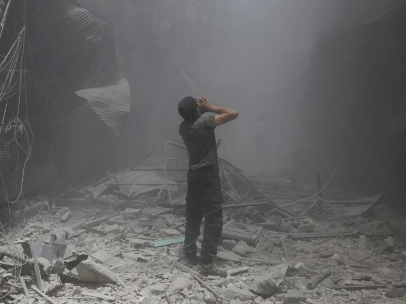 A Syrian man reacts following a reported air strike by Syrian government forces in the rebel-held neighborhood of Bustan al-Qasr on June 5, 2016. (AFP/Baraa al-Halabi)