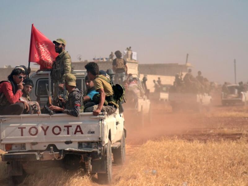 Syrian rebel fighters ride in the back of a pick-up truck flying an Islamist flag in the northern Syrian village of Rael after clashes with Daesh north of Aleppo on October 9, 2016. (AFP/Nazeer al-Khatib)