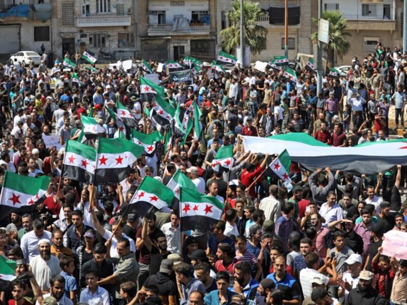 Syrian protesters wave the flag of the opposition as they demonstrate against the regime and its ally Russia, in the rebel-held city of Idlib on September 7, 2018. (OMAR HAJ KADOUR / AFP)