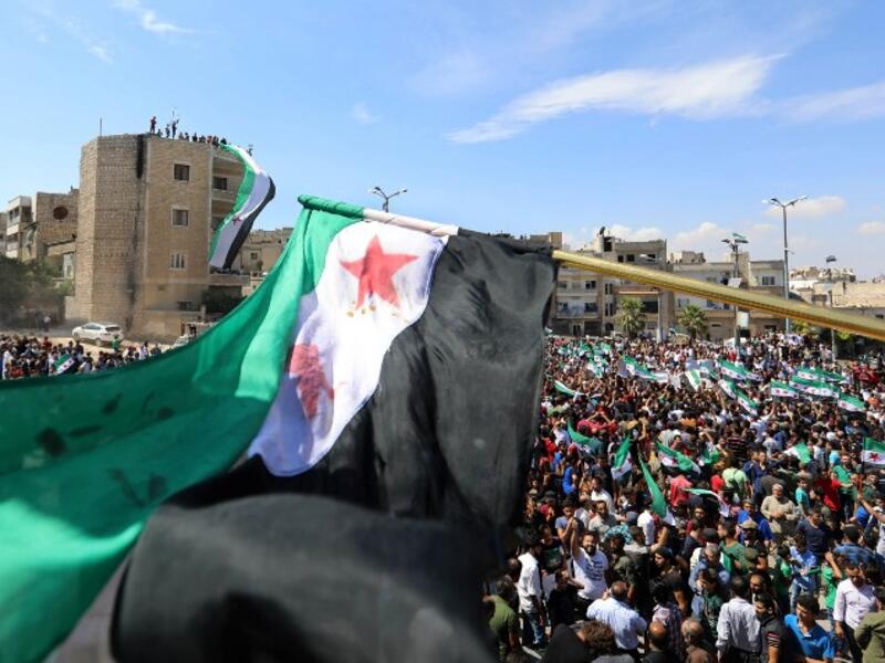 Syrian protesters wave the flag of the opposition as they demonstrate against the regime and its ally Russia, in the rebel-held city of Idlib on September 7, 2018. (OMAR HAJ KADOUR / AFP)