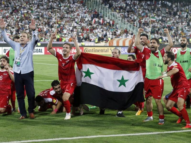 Syria's players celebrate at the end of their FIFA World Cup 2018 qualification football match against Iran on September 5, 2017. (Atta Kenare/AFP)