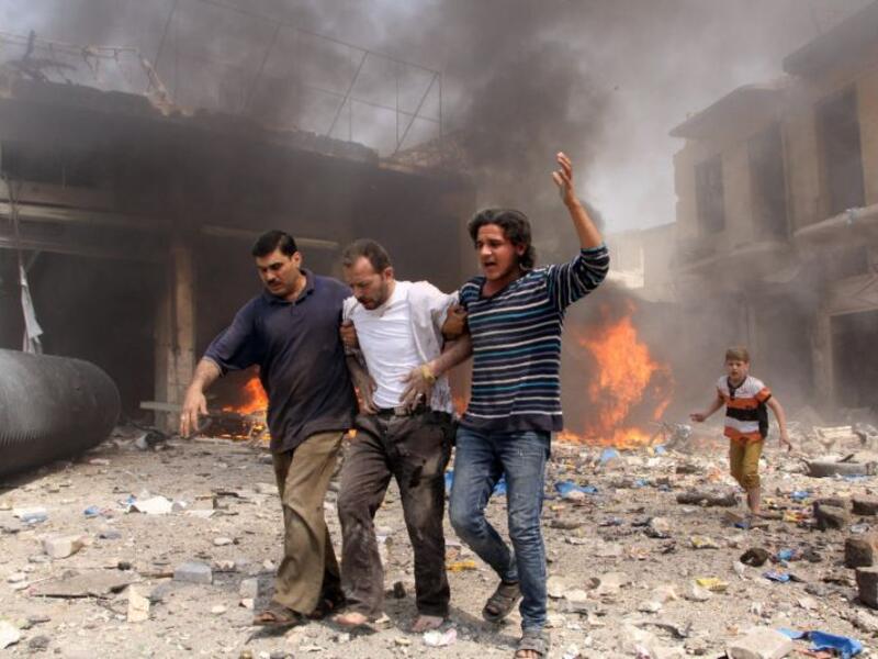 Walking through the destruction following a reported barrel bomb attack by Syrian government forces in the northern city of Aleppo. (AFP Photo/Karam al-Masri) 