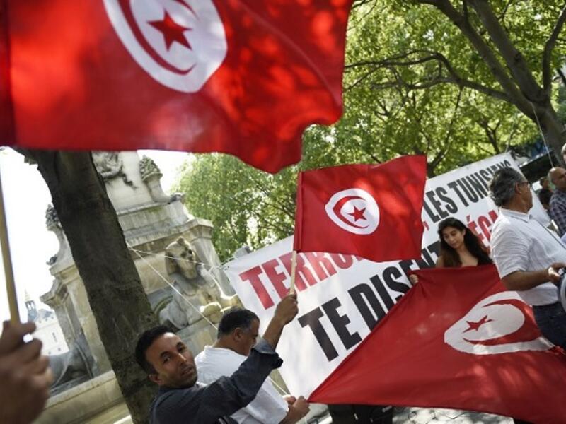 Protesters wave Tunisian flags during a demonstration against terrorism in Paris on June 27, 2015, a day after a deadly attack on a Tunisian beach resort. (Loic Venance/ AFP)