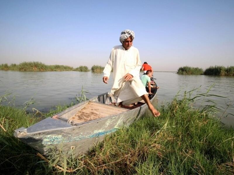 A "Marsh Arab" gets out of a boat in the al-Ahwar Marshlands in Iraq (AFP)