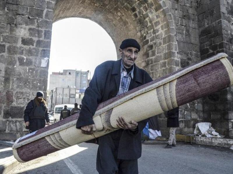 A displaced Kurdish man carries his belongings in Diyarbakir. (AFP/File)
