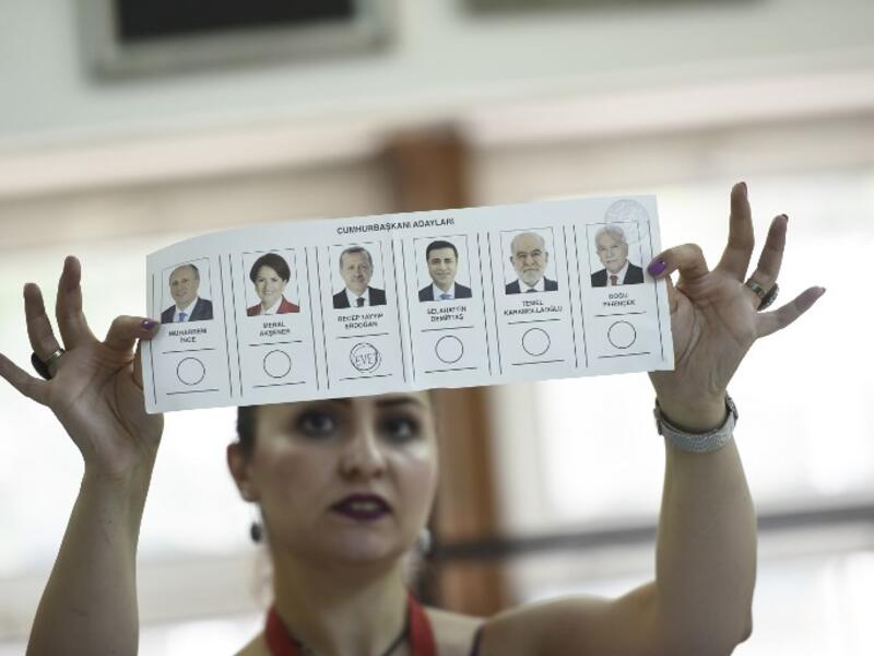 An election committee member shows a ballot displaying a vote for Recep Tayyip Erdogan, Turkish President and leader of the Justice and Development Party (AKP) at a polling station during the Turkish presidential and parliamentary elections in Istanbul on June 24, 2018. (Yasin AKGUL / AFP)