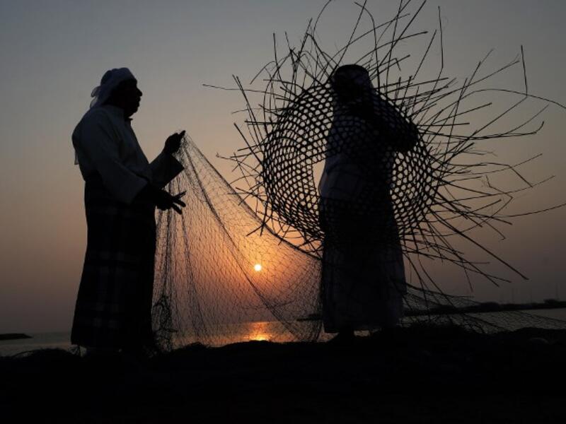 Emirati men weave a fishing net during the Dalma Sailing Festival, off of the coast of Dalma island in the Persian Gulf, about 40 kilometres off of the Emirati capital Abu Dhabi on October 27, 2018. (KARIM SAHIB / AFP)
