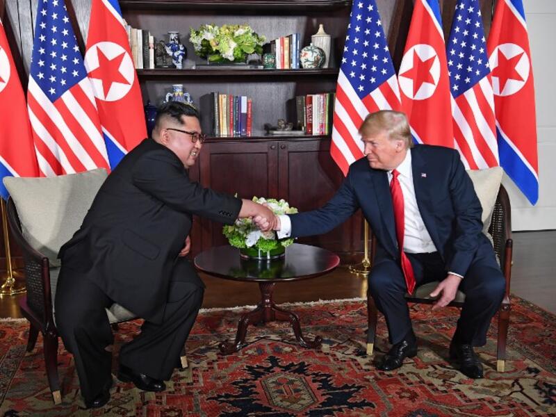 US President Donald Trump (R) shakes hands with North Korea's leader Kim Jong Un (L) as they sit down for their historic US-North Korea summit, at the Capella Hotel on Sentosa island in Singapore on June 12, 2018. (SAUL LOEB / AFP)