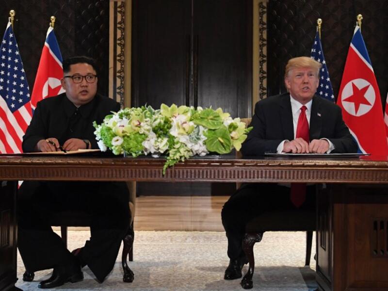 US President Donald Trump (R) speaks while seated with North Korea's leader Kim Jong Un (L) at a signing ceremony during their historic US-North Korea summit, at the Capella Hotel on Sentosa island in Singapore on June 12, 2018. (SAUL LOEB / AFP)
