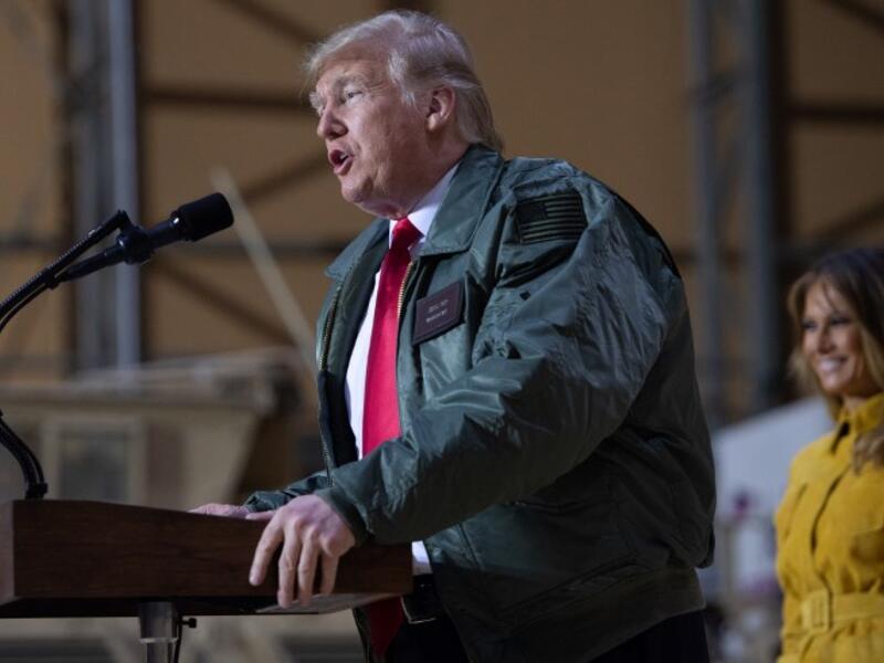 US President Donald Trump speaks to members of the US military as First Lady Melania Trump looks on during an unannounced trip to Al Asad Air Base in Iraq, December 26, 2018.
SAUL LOEB / AFP