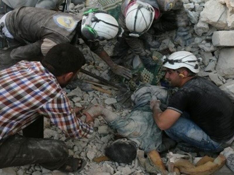 Members of The White Helmets retrieve a body from the rubble in Aleppo (AFP/Ameer Alhalbi)