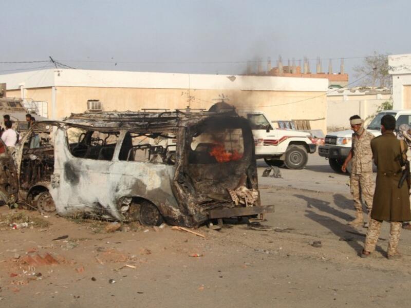 Yemenis check a burning vehicle following a reported suicide car bombing in Huta, the capital of the southern province of Lahj, a bastion of Al-Qaeda militants, on March 27, 2017. (AFP/Saleh al-Obeidi)