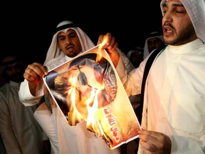 Kuwaiti protesters set ablaze a picture of Lebanese Shiite movement Hezbollah's chief Hassan Nasrallah during a protest in front the Lebanese embassy against Hezbollah's and Iran's involvement in Syria, in Kuwait city on June 11 (Yasser al-Zayyat / AFP)
