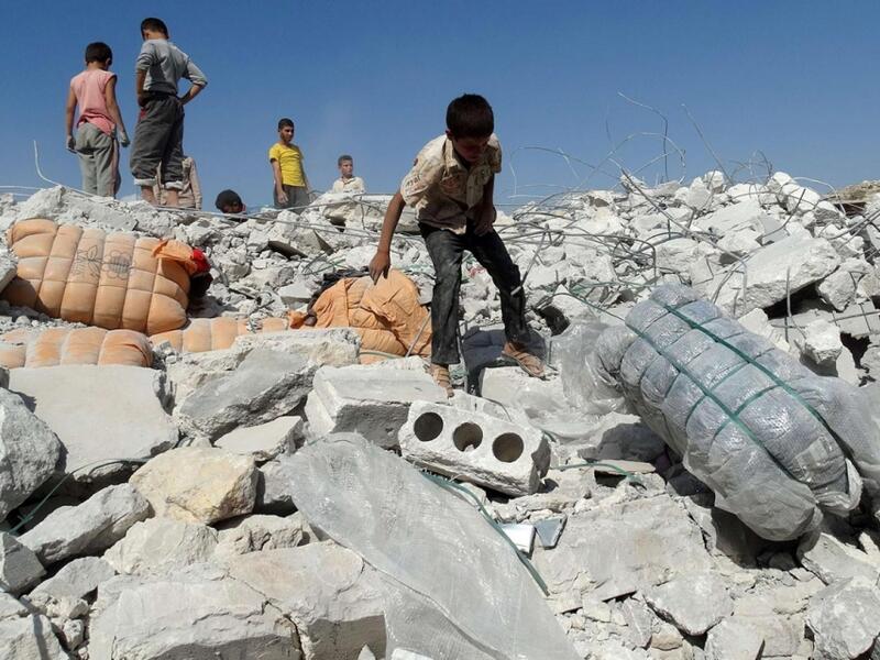 Young Syrians survey the damage from a regime airstrike. (AFP/File)