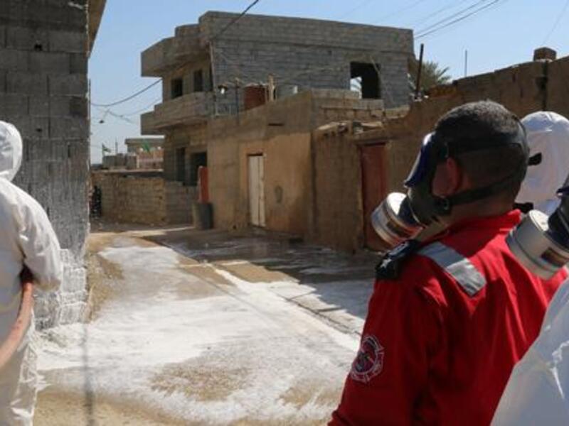 Members of the civil defence spray and clean areas in the town of Taza, around 220 kilometres north of the capital Baghdad, on Sunday. (AFP/File)
