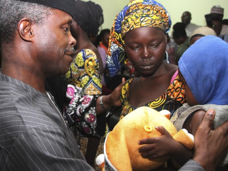 One of the 21 freed Chibok girls cries while holding her baby as Nigerian Vice President Yemi Osinbajo looks on at his office in Abuja on October 13, 2016. (AFP/Philip Ojisua)