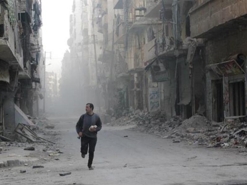 A Syrian rebel runs through a street in Aleppo during clashes with government troops. (AFP/File)