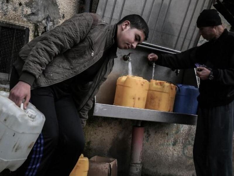 Palestinians fill bottles and jerrycans with drinking water from public taps at the Rafah refugee camp in southern Gaza Strip, on February 22, 2017. (Said Khatib/AFP/File)