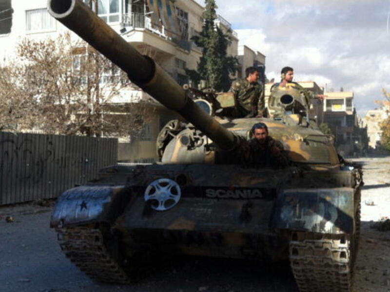 Syrian pro-government forces patrol in their tank in the town of Nabak near Damascus on December 7, 2013. [Getty Images]
