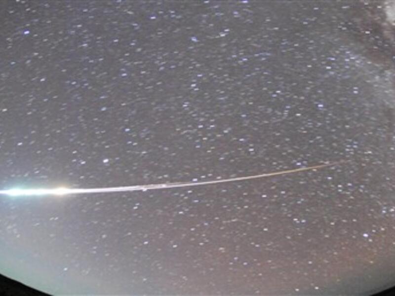 AUSTRALIA, Woomera : A handout photo taken with a fish-eye lens on June 13, 2010, and released on June 14 shows the capsule carried by the Hayabusa spacecraft burning up over South Australia on re-entry, leaving the heat-resistant pod to parachute back to land within the Woomera military zone.  