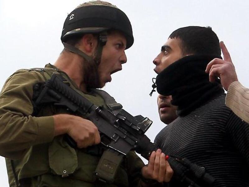A Palestinian resident of the northern West Bank village of Madama argues with an Israeli soldier after security forces came to intervene in clashes between Palestinian farmers and Israeli settlers from the Yitzhar settlement, on Monday. (AFP PHOTO/JAAFAR ASHTIYEH)