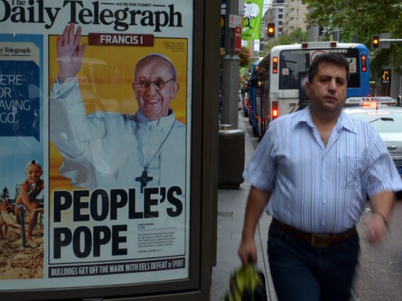 A man walks past an advertising billboard displaying the front page of Sydney's tabloid newspaper the Daily Telegraph with picture of Pope Francis, Argentina's Jorge Mario Bergoglio. (AFP PHOTO/ Saeed KHAN)