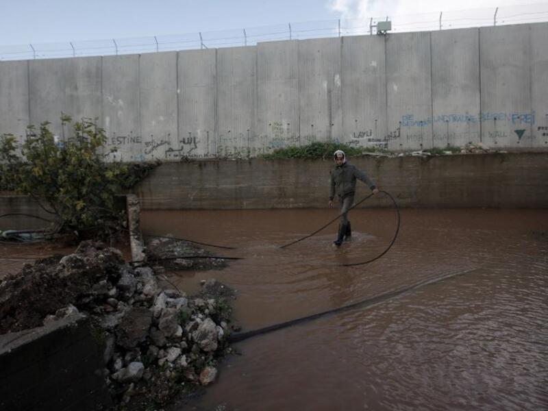A Palestinian boy stands in a flooded area adjacent to Israel's controversial separation barrier near the West Bank city of Qalqilya (AFP PHOTO/JAAFAR ASHTIYEH)