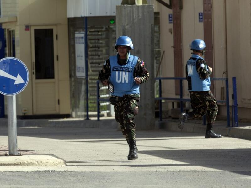Filipino UN peacekeepers cross the Quneitra checkpoint between Israel and Syria in the Golan Heights on Saturday. (AFP PHOTO/AHMAD GHARABLI)