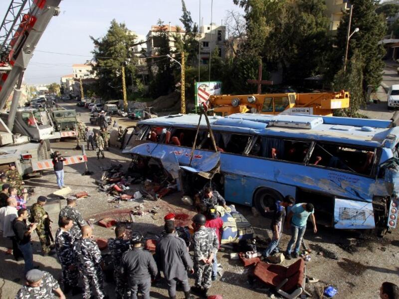 Lebanese security forces and civilians inspect the scene of a bus crash, killing and wounding several people, in the town of Kahaleh, ten kilometres east of Beirut on March 15, 2013, that was carrying Syrian refugees upon their arrival from Syria to Lebanon. (AFP PHOTO/ ANWAR AMRO)