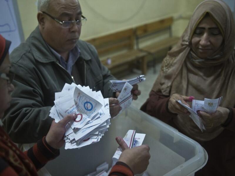 Polling station officials count ballots in the Egyptian capital Cairo on January 15, 2014 at the end of the second day of voting in a referendum on a new constitution. [AFP]