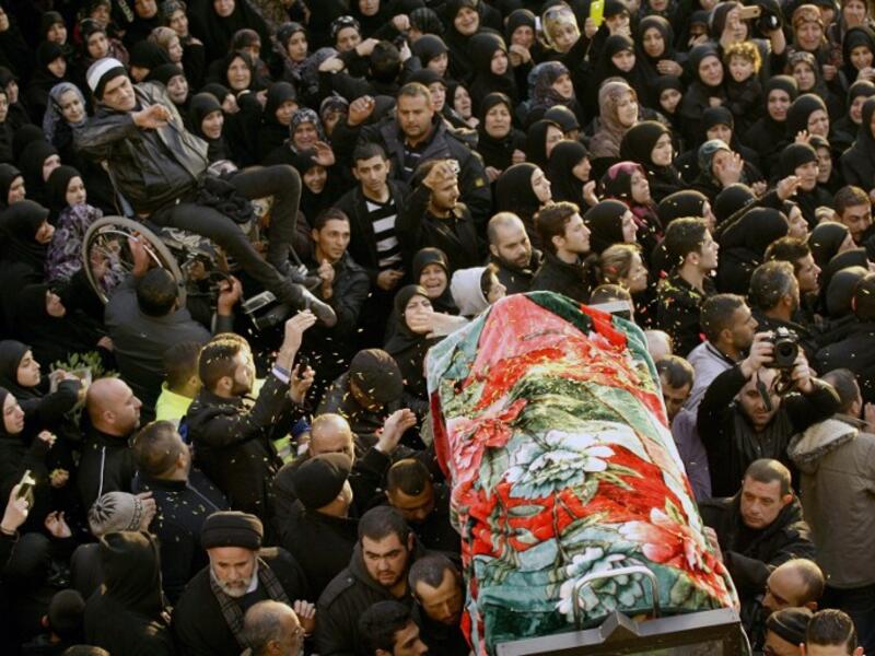 People carry one of the two bodies during the funeral of Malak Zahwa and her step-mother Iman Hijazi, who both died in a car bomb that targeted a Beirut's suburb the day before on January 3, 2014. The death toll of the blast has now risen to six. (AFP)
