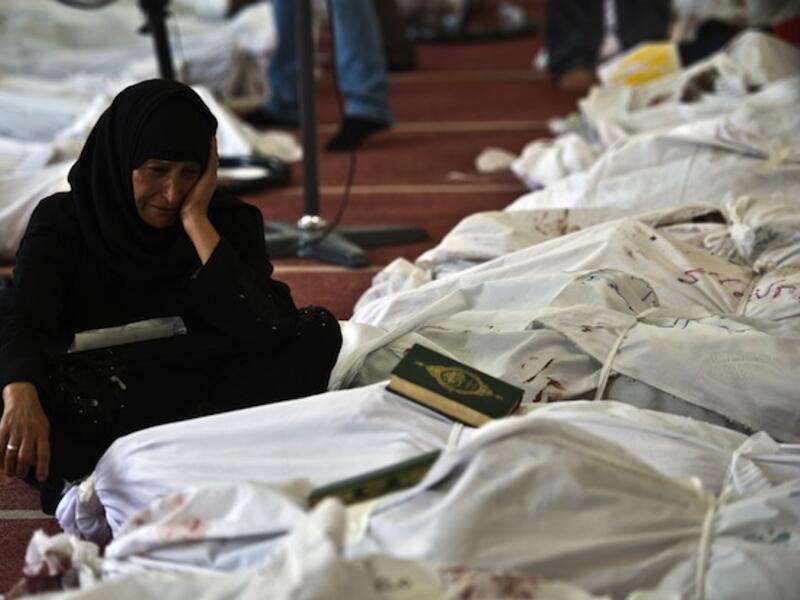 An Egyptian woman mourns over the body of her daughter wrapped in shrouds at a mosque in Cairo on August 15, 2013, following a crackdown on the protest camps of supporters of ousted Islamist president Mohamed Morsi the previous day. (AFP)