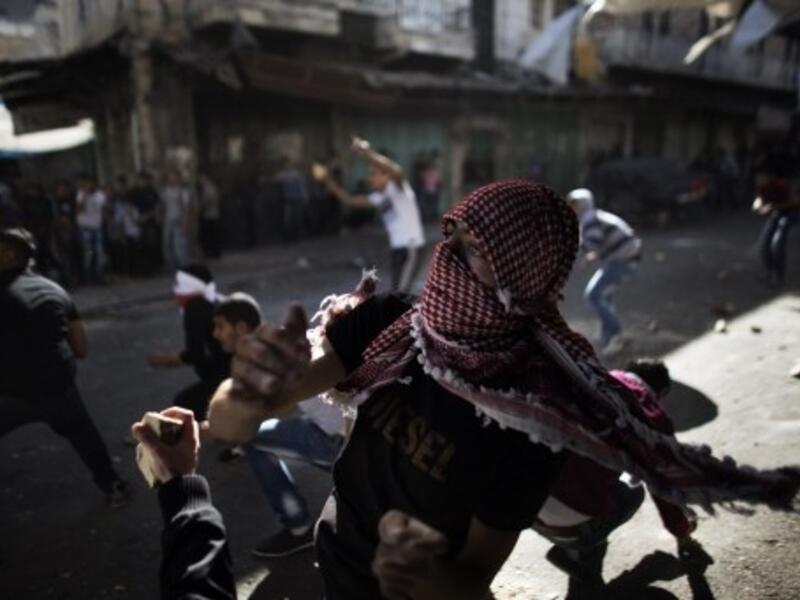 Palestinian stone throwers confront Israeli soldiers in the southern West Bank city of Hebron on September 23, 2013, as tensions run high following the death of an Israeli soldier. (AFP)