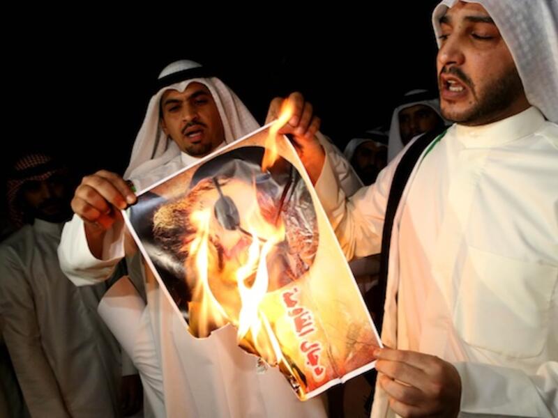 Kuwaiti protesters set ablaze a picture of Hezbollah's chief Hassan Nasrallah during a protest in front the Lebanese embassy against Hezbollah's and Iran's involvement in Syria on Tuesday. AFP photo