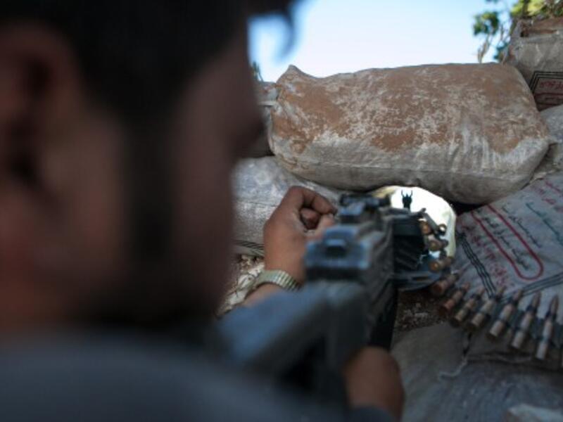  A Syrian rebel fighter points his rifle through a hole in sandbags as he holds a position in a trench, 100m away from the regime-controlled military base of Wadi Deif in Idlib province. AFP photo