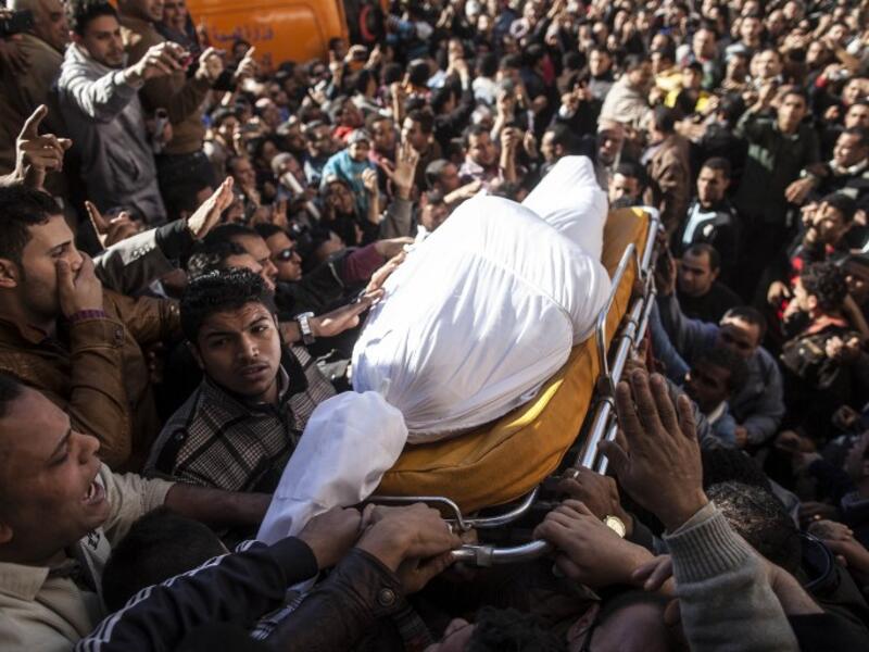 Egyptians carry the body of one of the thirteen people killed in a car bomb attack earlier in the day, during his funeral in the Egyptian city of Mansura, North of Cairo, on December 24, 2013. (AFP)
