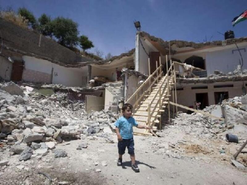 A Palestinian boy walks near the rubble of his family's destroyed house after Israeli bulldozers razed it down the previous day in the east Jerusalem neighborhood of Jabal Mukabbir in May. AFP Photo