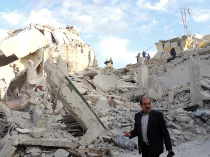 People walk past the rubble of buildings that were reportedly destroyed during regime air strikes in Aleppo city's eastern Tariq al-Bab district on November 23, 2013. Alongside destruction inside Syria, Lebanese towns have also been the target of regime planes. (AFP)
