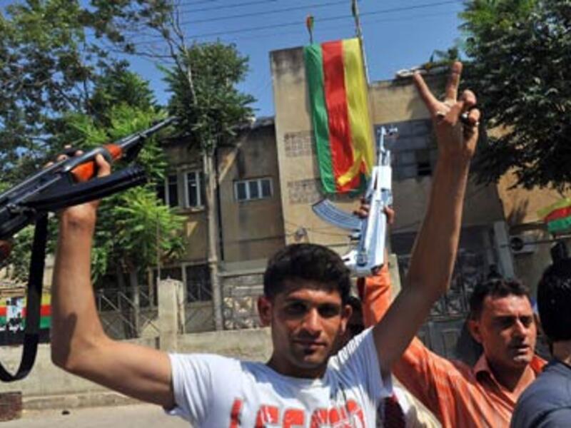 Syrian Kurds hold their rifles, as they flash the sign for victory, in the Kurdish town of Jinderes, near the northern Syrian city of Aleppo. (Photograph: Bulent Kilic/AFP/Getty Images)