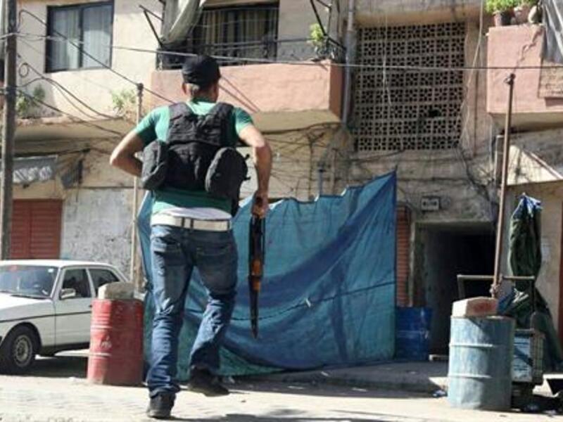 A gunman carries a rifle as he runs in Tabbaneh area in Tripoli, Tuesday, Oct. 22, 2013. (The Daily Star/Antoine Amrieh)