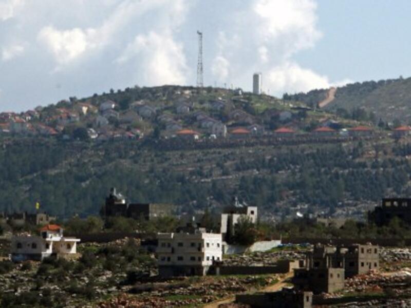 The general view of the Jewish settlement of Itamar (background) behind the West Bank village of Awarta. Israeli settlers are seeking approval for hundreds of homes in the northern West Bank. AFP photo