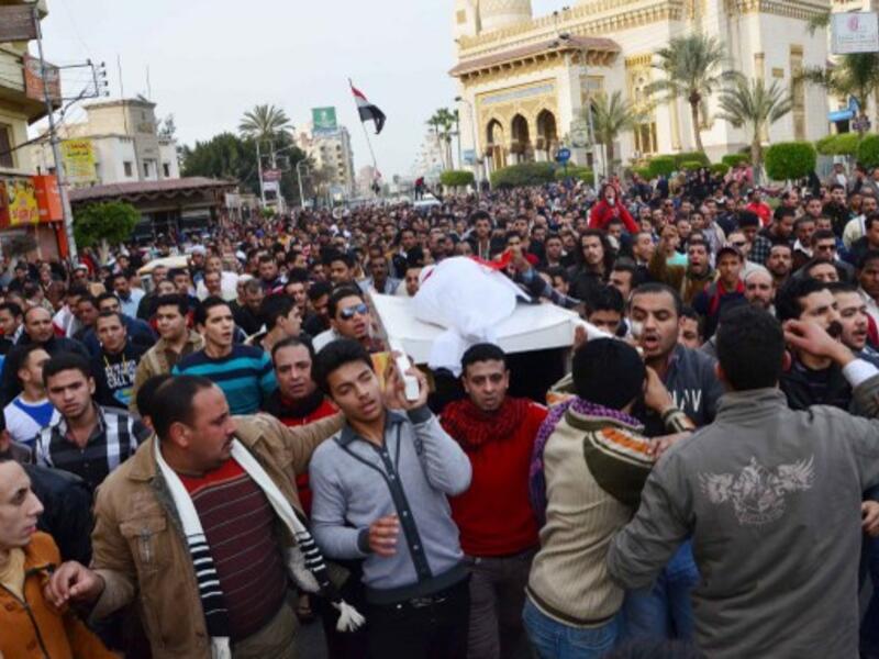 Egyptians carry the body of a person killed in overnight clashes between police and protesters in Egypt's Nile Delta city of Mansura, on Saturday. (Photo: AFP / STR)
