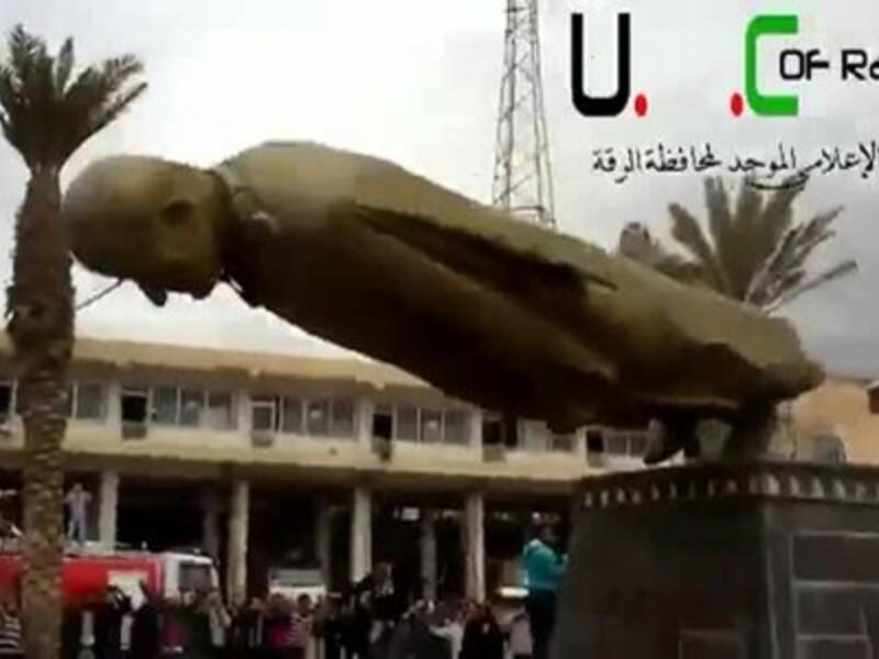 An image grab taken from a video uploaded on YouTube shows Syrian anti-regime protesters destroying a statue of former president Hafez al-Assad after rebels overran the northern city of Raqqa on Monday. (Photo: AFP Photo / YouTube)