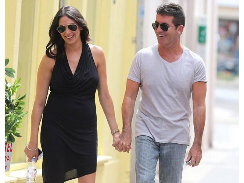 Hand in hand: Simon Cowell and girlfriend Lauren Silverman smile away as they stroll along on a lunch date. (Image: Facebook)